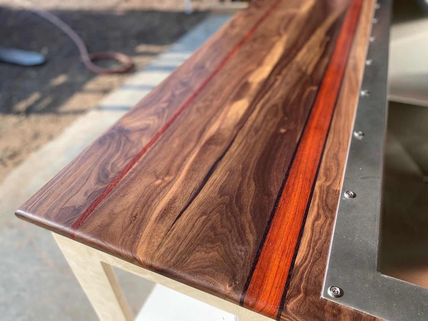 Malibu 66" cold plunge tub close up of the deck with black walnut and padauk and wenge streamers with stainless steel tub. 