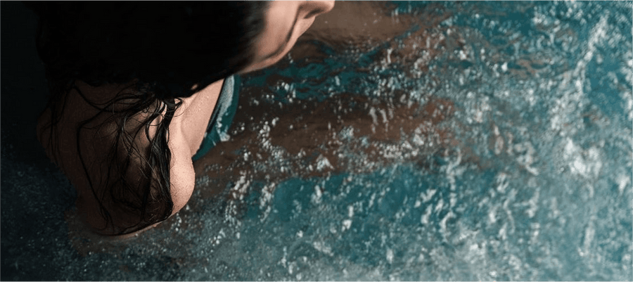 shoulder of a woman in a bluecube ice bath cold plunge tub