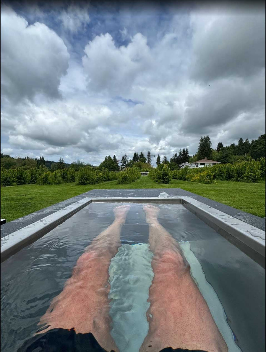 Open-air leg soak in a BlueCube C2 black cold plunge overlooking the pasture at Fyre Sauna in Redmond, WA