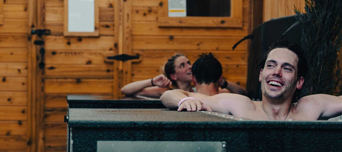 Two members in BlueCube cold plunges in a commercial gym recovery room
