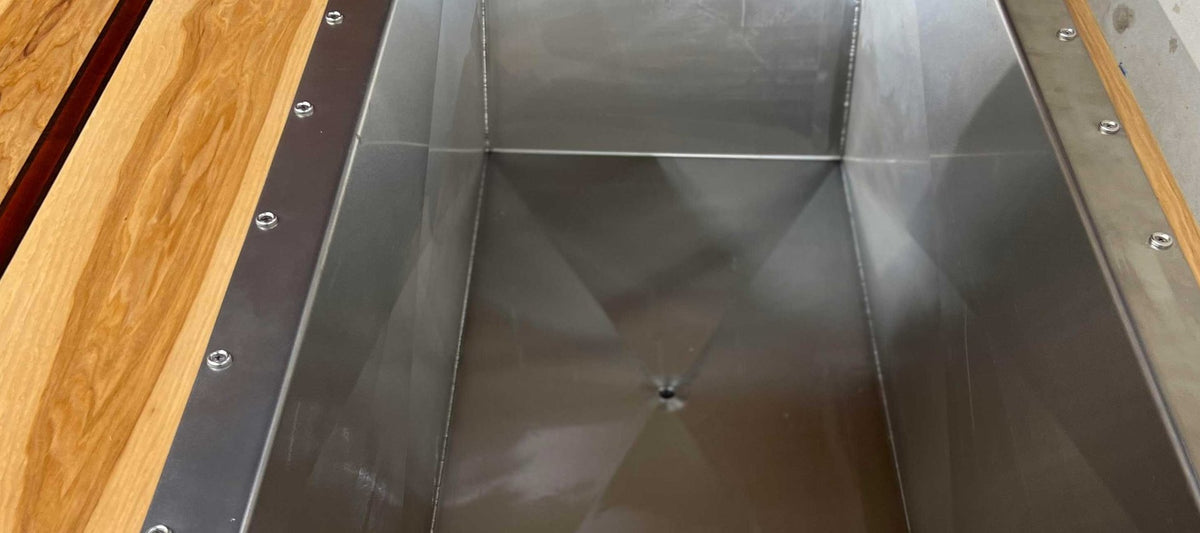 Raw 316-L stainless cold plunge basin set in a hardwood deck