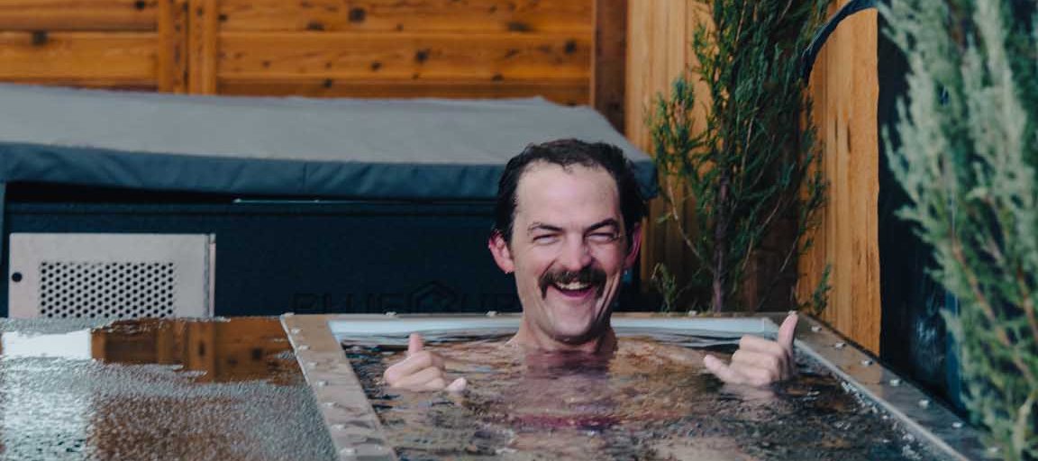 Smiling man giving shakas in a BlueCube cold plunge