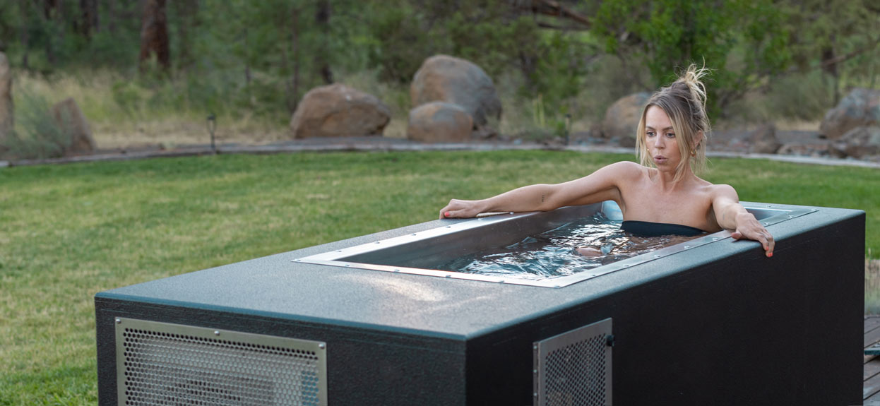 CoreChill cold-plunge tub with woman model in backyard