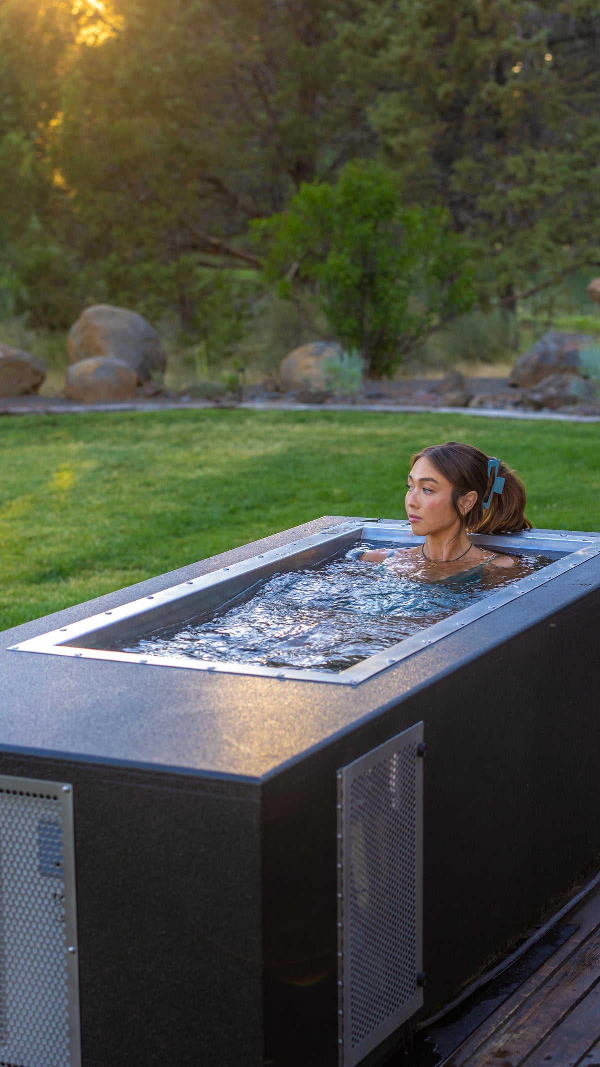 CoreChill³ cold plunge tub with a female model on a outdoor patio. 