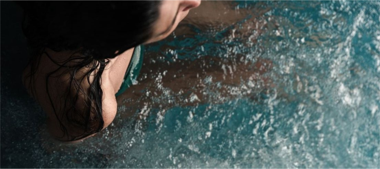 shoulder of a woman in a bluecube ice bath cold plunge tub