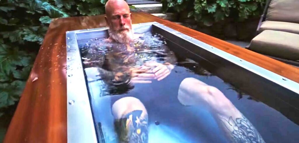 Owner Josh Sirlin fully immersed in a custom BlueCube C2 cold plunge with mahogany deck at Black Bear Brand in Seattle, WA
