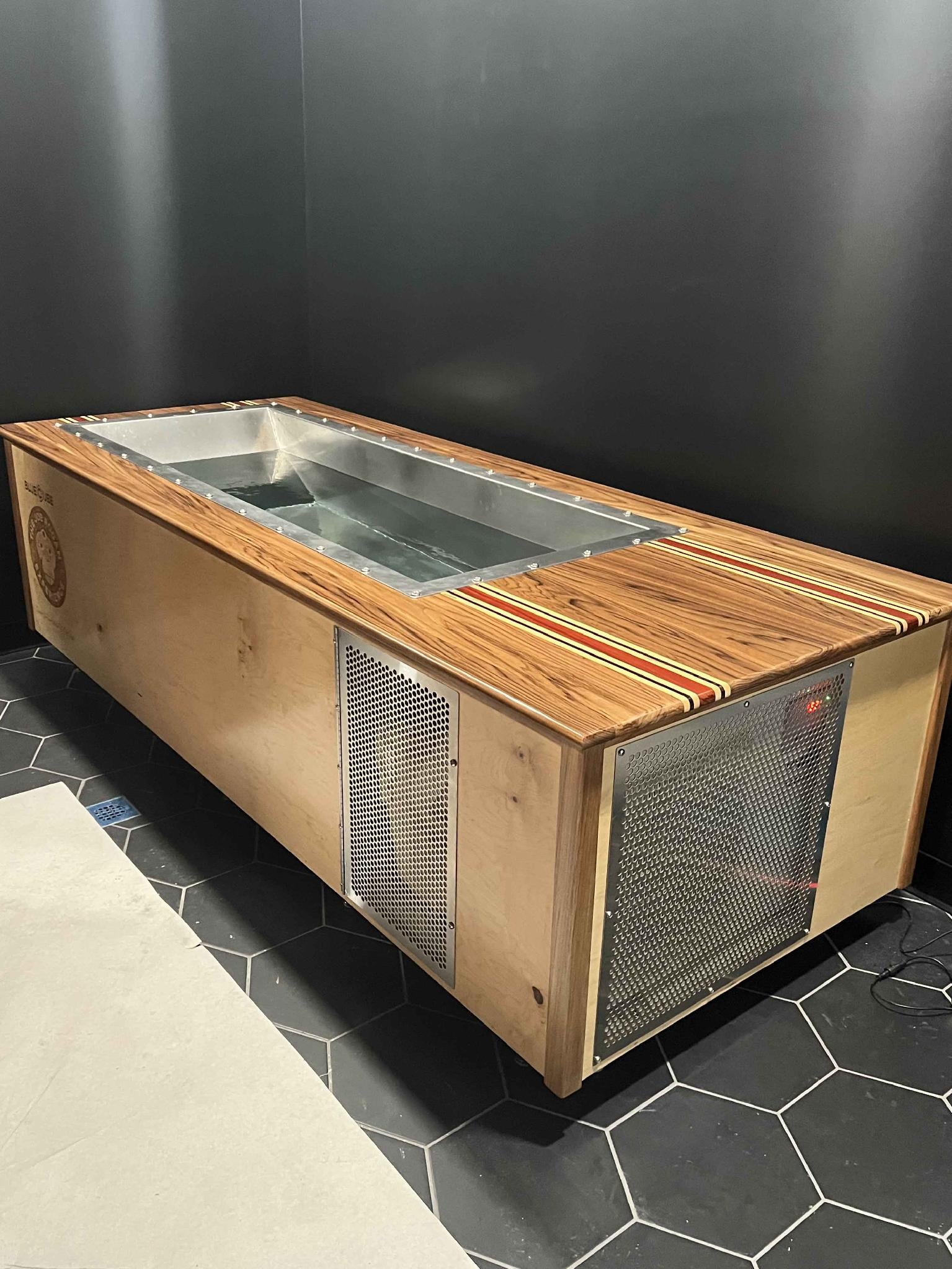 Joe Rogan's first BlueCube cold plunge at the JRE studio — an all-wood model with a marine-grade stainless tub